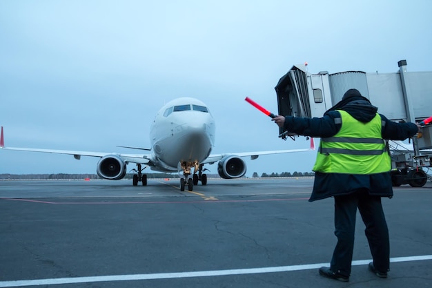 Aircraft marshalling at the aiport apron Passenger airplane meeting