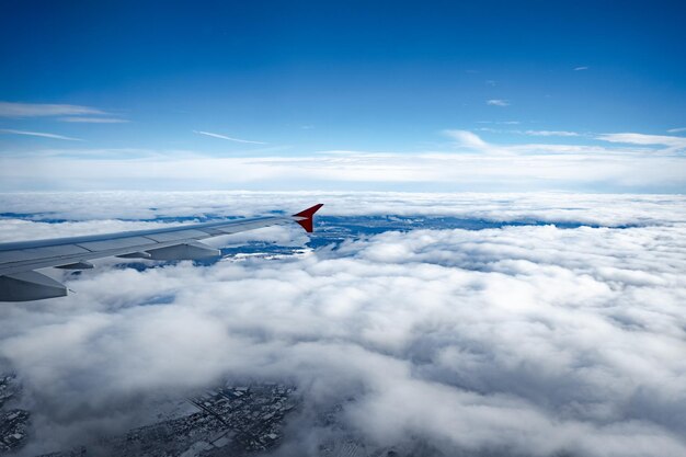 Photo aircraft wing above beautiful clouds and blue sky