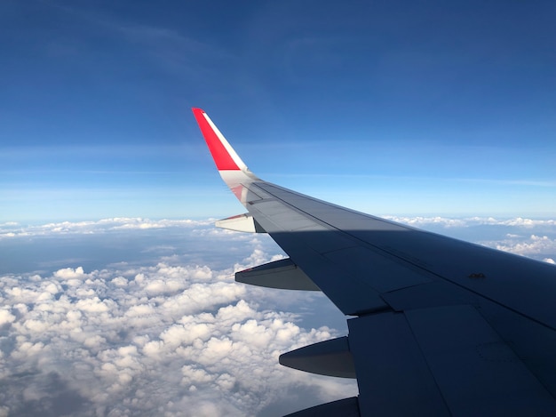 Aircraft wing is flying in the blue sky with white clouds