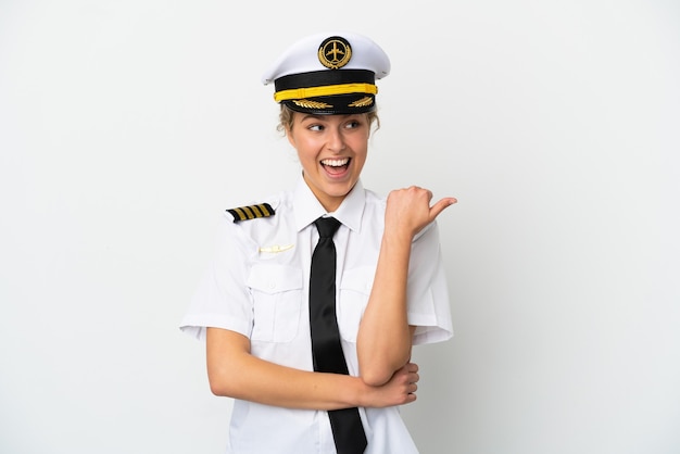 Airplane blonde woman pilot isolated on white background pointing to the side to present a product