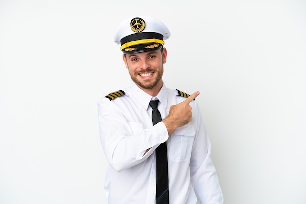 Airplane Brazilian pilot isolated on white background pointing to the side to present a product