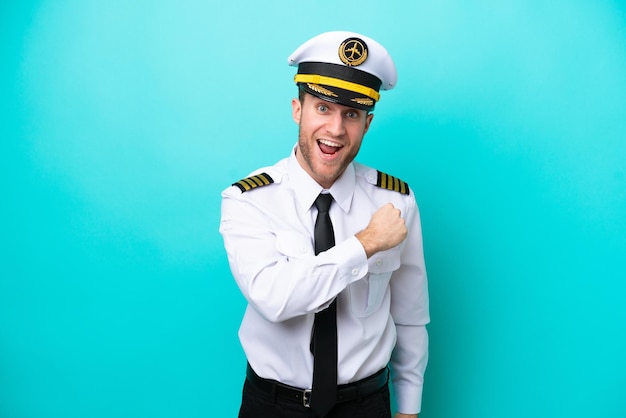 Airplane caucasian pilot isolated on blue background celebrating a victory