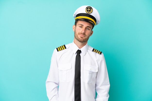 Airplane caucasian pilot isolated on blue background laughing