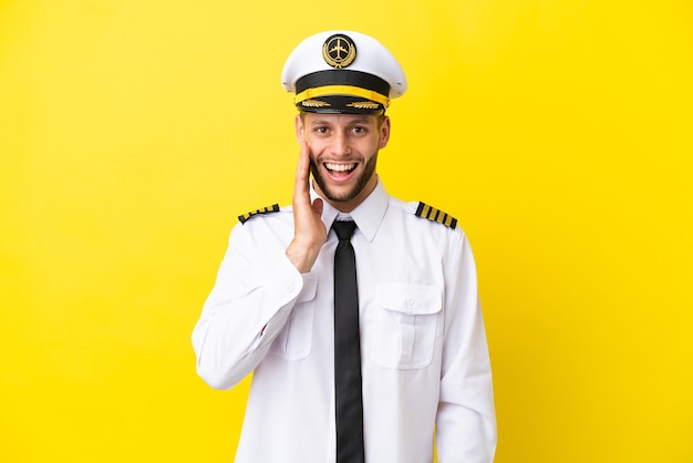 Airplane caucasian pilot isolated on yellow background with surprise and shocked facial expression