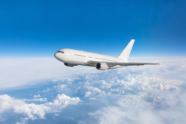 Airplane fly in the blue sky in below the clouds.