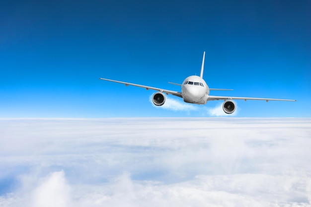 Airplane fly over the clouds and the earth's surface under the blue sky