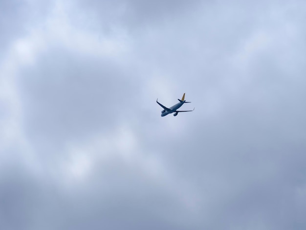 An airplane flying in the cloudy sky