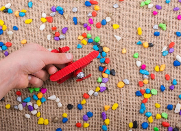 Airplane in hand amid colorful pebbles