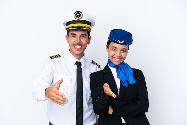 Airplane pilot and mixed race air hostess isolated on white background shaking hands for closing a good deal