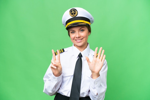 Airplane pilot woman over isolated chroma key background counting seven with fingers