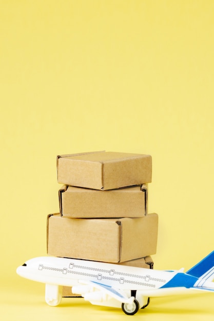 Airplane and stack of cardboard boxes. concept of air cargo and parcels, airmail. Fast delivery of goods and products. Cargo aircraft. Logistics, connection to hard-to-reach places. Banner, copy space