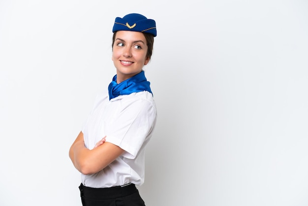 Airplane stewardess caucasian woman isolated on white background with arms crossed and happy