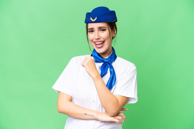 Airplane stewardess over isolated chroma key background celebrating a victory