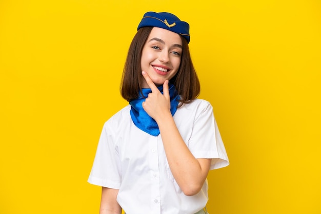 Airplane stewardess Ukrainian woman isolated on yellow background smiling