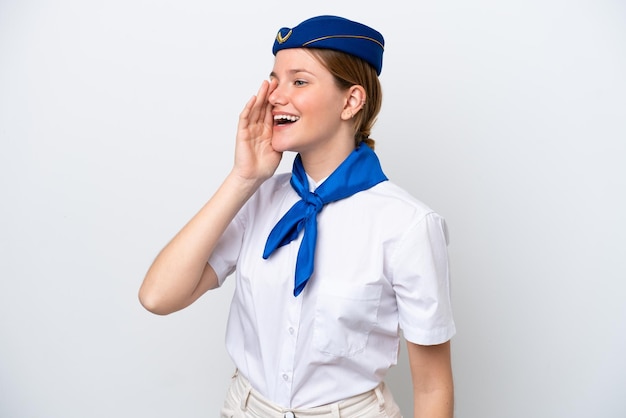 Airplane stewardess woman isolated on white background shouting with mouth wide open to the lateral