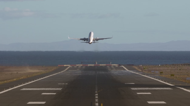 Airplane taking off and flying over the sea