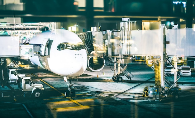 Airplane at terminal gate preparing takeoff by night