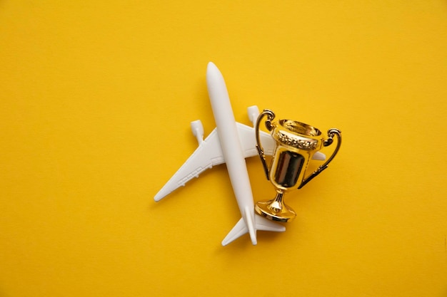 Airplane travel awards. Aviation business satisfaction. Toy airplane with gold trophy.