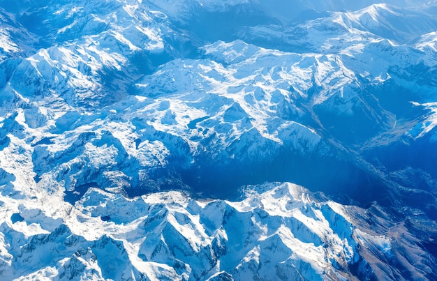 Airplane view of blue mountains covered with white snow Can be used as nature background