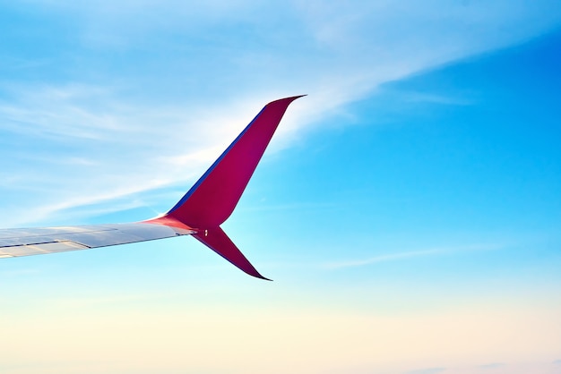 Airplane wing andblue sky with clouds