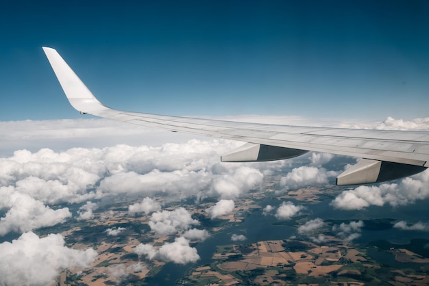 Airplane wing over clouds against blue sky