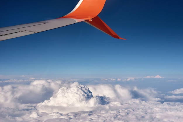 Airplane wing and fluffy cloud, view from the airplane window