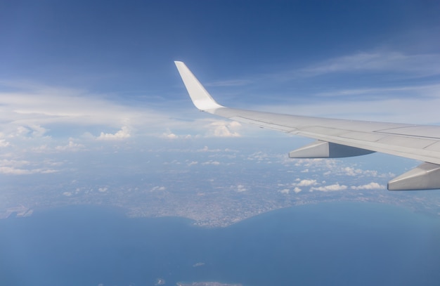 Airplane wing view out of the window the cloudy sky background