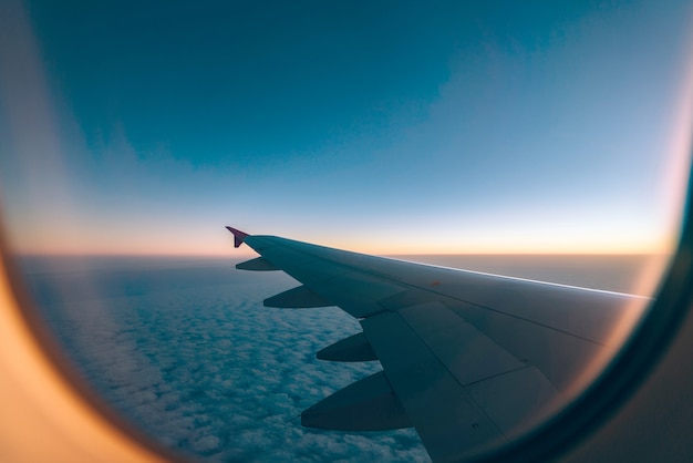 Airplane wing with sunrise in light flare