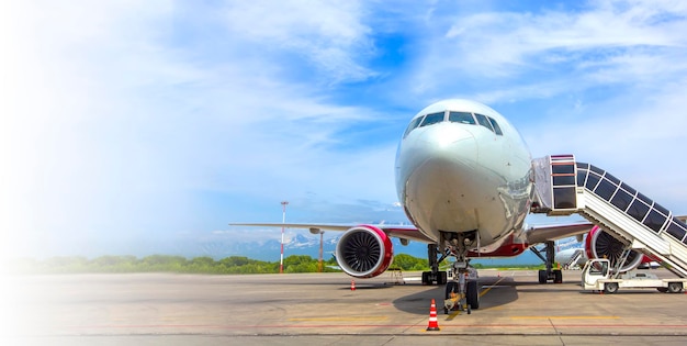 Airplane with a passenger boarding steps on the airport apron