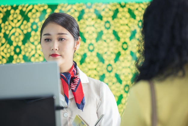 At the airport checkin counter a passenger hands over his documents to the manager via a counter ticket