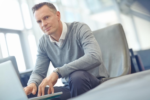 Airport lounge portrait and business man typing review of financial portfolio stock market database or investment Economy travel or crypto trader working on forex bitcoin mining or nft trading