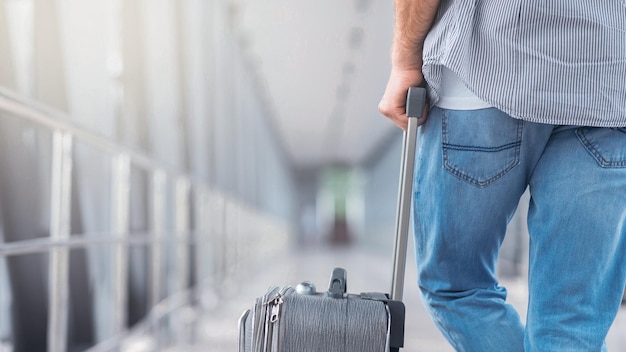 At airport man with luggage standing in terminal walkway preparing for flight empty space