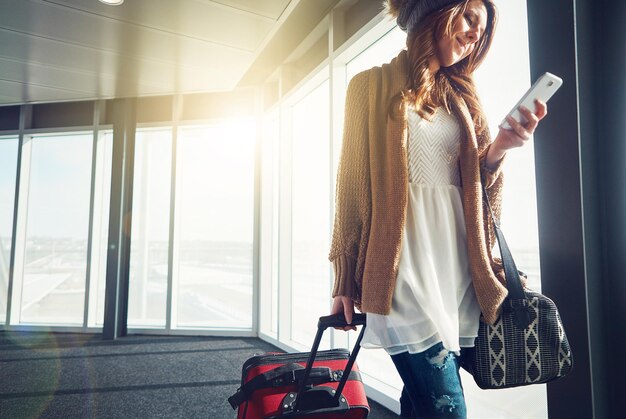 Photo airport reading and woman with phone suitcase and texting in california holiday and vacation traveller tourist and break for person journey and travel in usa luggage and smile for mobile