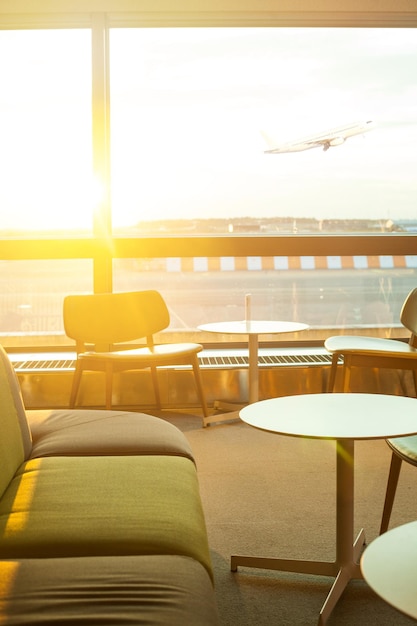 Airport terminal background Modern international airport during sunset Airplane departure at sunset through the gate airport cafe window