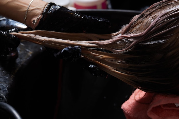 Airtouch Hair stylist makes bouffant using comb on thin strands Shatush technique for hair lightening