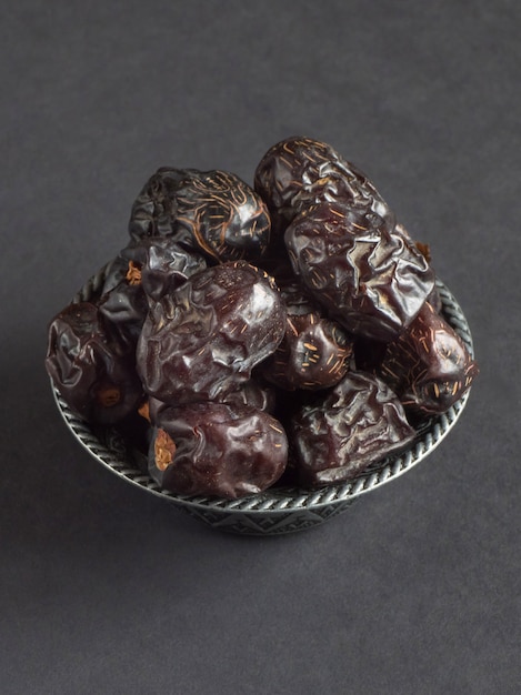 Ajwa Al-Madina dates are laid out on a black table.