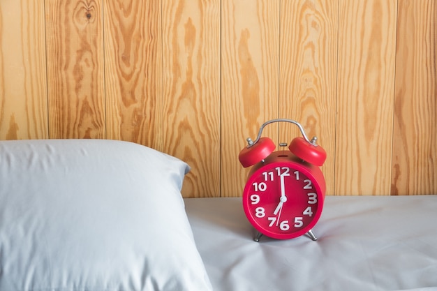 Alarm clock on bed in bedroom