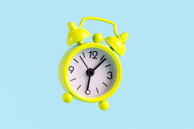 Alarm clock on a blue background. Early awakening, good morning