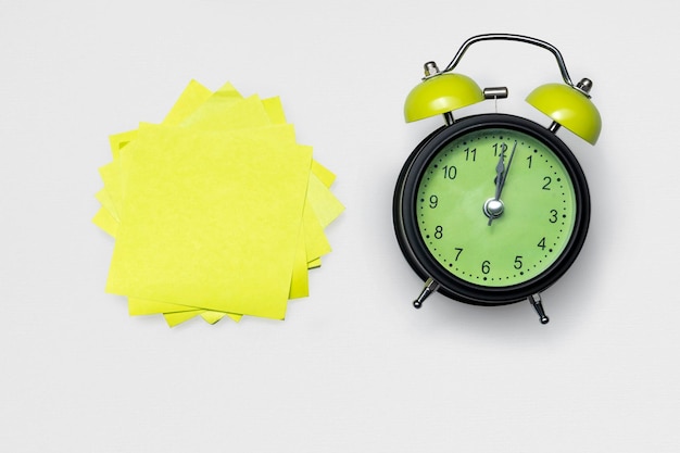 The alarm clock and empty note paper for copy space on a white background