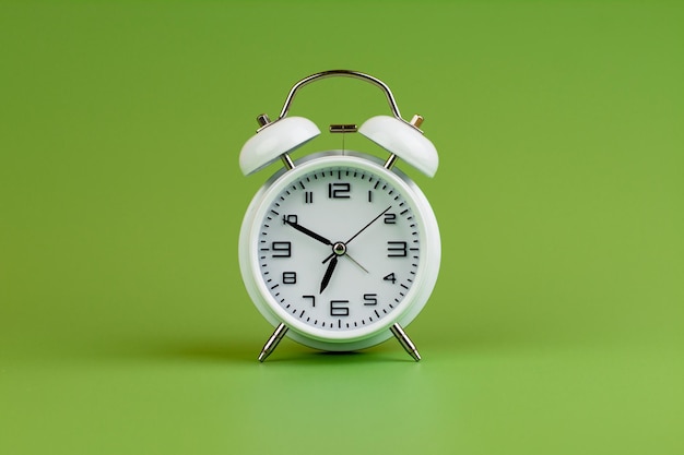 Alarm clock on green background time concept clock photo