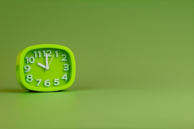 Alarm clock on green background time concept clock photo