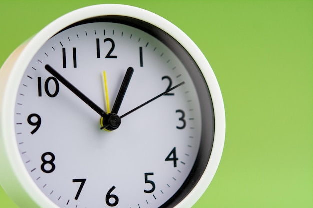 Alarm clock on green background time concept clock photo