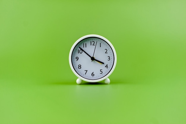 Alarm clock on green background time concept working with time precious time