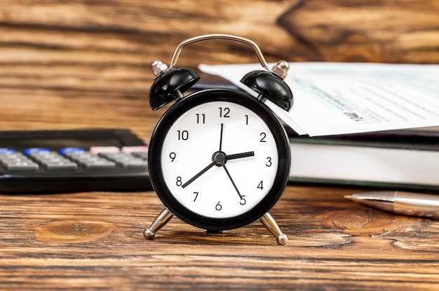 Alarm clock on the office workplace Business concept