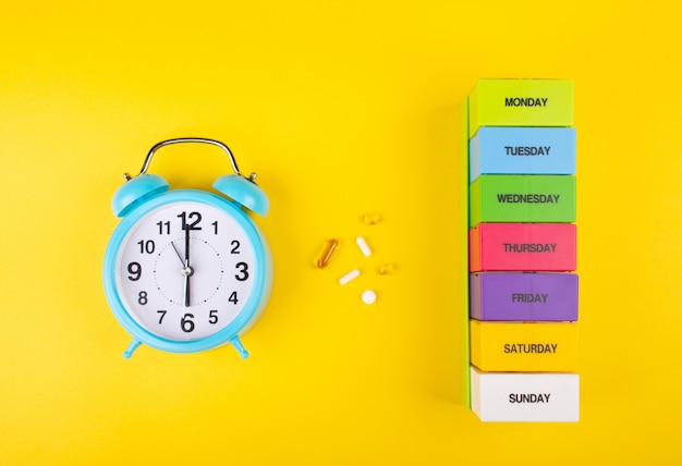 Alarm clock, pills and a pill organizer 