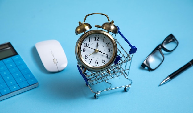 Alarm clock shopping cart on the blue background