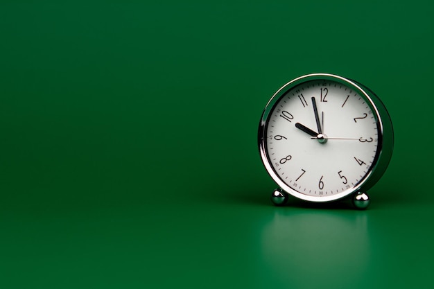 Alarm clock silver white dial on green screen Working with time Be on time Keep time Value time concept