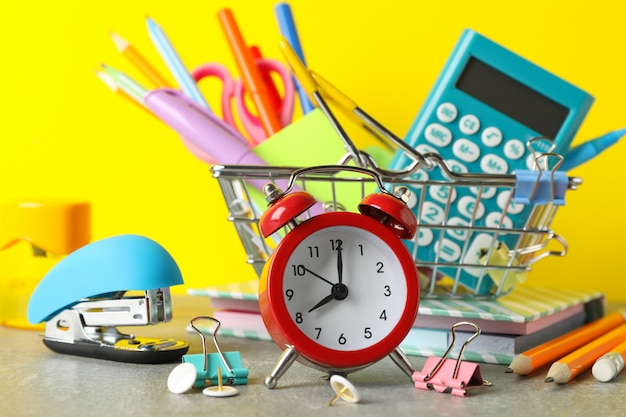 Photo alarm clock and stationary on grey table, close up