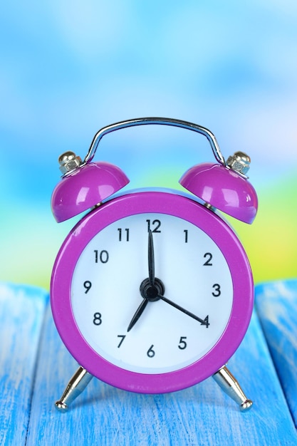 Alarm clock on table on blue background