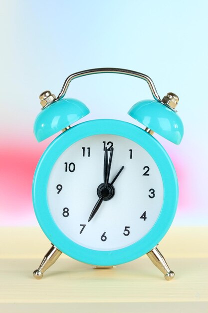 Alarm clock on table on light background